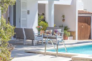 a patio with chairs and a table next to a swimming pool at Landhaus mit Garten, Sonnenterrasse sowie überdachter Terrasse und Pool in Strandnähe in Cala Ratjada +14 photos