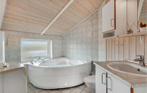 a bathroom with a tub and a toilet and a sink at Pet Friendly Home In Hvide Sande in Bjerregård +18 photos