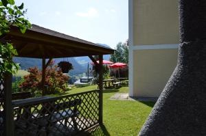 a patio with benches and umbrellas and a table at Residence Granvara in Ortisei