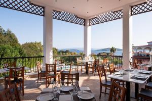 a restaurant with tables and chairs on a patio at Alexandros Palace in Ouranoupoli