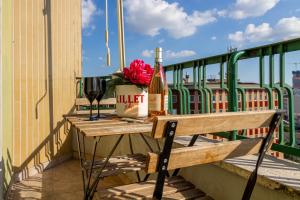 a table with a bottle of wine and flowers on a balcony at Moderno Appartamento Navigli Milano:Two Nice Jacks in Milan