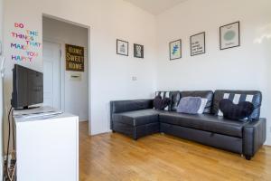 a living room with a couch and a tv at Moderno Appartamento Navigli Milano:Two Nice Jacks in Milan