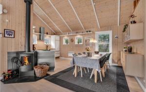 a kitchen and dining room with a table and a fireplace at Holiday Home Tranebærvej Tarm Ix in Hemmet
