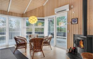 a dining room with a table and chairs and a fireplace at Holiday Home Tranebærvej Tarm Ix in Hemmet