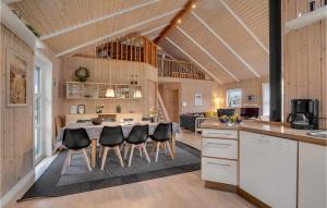a kitchen and dining room with a table and chairs at Holiday Home Tranebærvej Tarm Ix in Hemmet