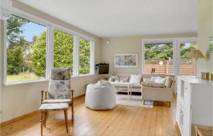 a living room with windows and a couch at Awesome Home In Væggerløse With Kitchen in Marielyst