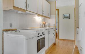 a kitchen with white cabinets and a sink at Awesome Home In Væggerløse With Kitchen in Marielyst