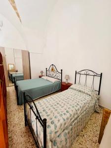 a bedroom with two beds in a room at Nonna Annunziata, Casa tipica Salentina vicino le spiagge in Gemini
