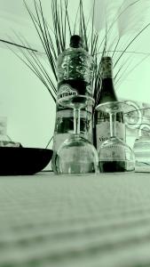 a close up of a bottle and glasses on a table at One bedroom TEA apartment Il-Gzira in Il-Gżira