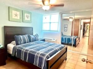 a bedroom with a bed and a mirror at Oceanview Costa del Mar Condo with Pool and Smart TV in Pole Ojea