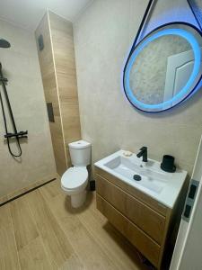 a bathroom with a toilet and a sink with a mirror at South Beach Apartment Primorsko in Primorsko
