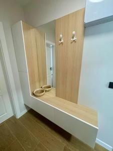 a bathroom with a wooden cabinet with a toilet in it at South Beach Apartment Primorsko in Primorsko