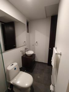 a bathroom with a white toilet and a sink at Apto CENTRAL B VALENCIA in Popayan +3 photos