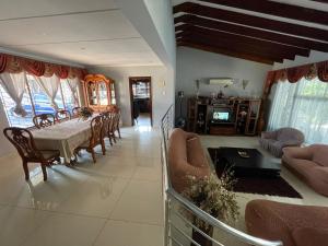 a dining room and living room with a table and chairs at Mbathos guesthouse in Durban