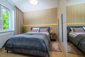 Un dormitorio con dos camas y una ventana. en Donna Aparts 2, en Jastrzębia Góra