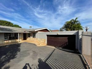 a house with a garage and a fence at Mbathos guesthouse in Durban