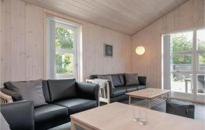 a living room with two couches and a table at Four-Bedroom Holiday Home In Lokken in Løkken