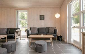 a living room with a couch and a table at Four-Bedroom Holiday Home In Lokken in Løkken