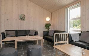 a living room with couches and a table at Four-Bedroom Holiday Home In Lokken in Løkken +16 photos