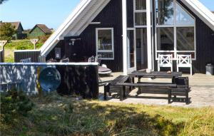 a house with a picnic table in front of it at Holiday Home Nymandsbjerg Hvide Sande X in Bjerregård