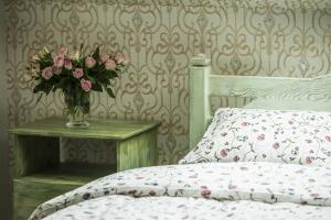 シェミャティチェにあるFolwark Księżnej Annyのベッドルーム1室(ベッド1台、テーブルの上に花瓶1枚付)