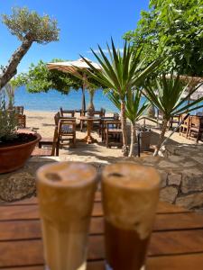 two drinks on a wooden table near the beach at Carpe Diem Apartments in Psakoudia +23 photos