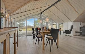 a dining room with a table and chairs at Holiday Home Ringvejen X in Lakolk