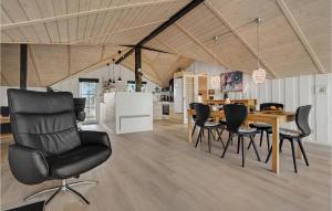a dining room with a table and black chairs at Holiday Home Ringvejen X in Lakolk