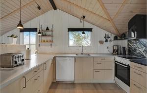 a large kitchen with white cabinets and a sink at Holiday Home Ringvejen X in Lakolk