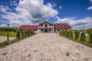 a large house with a red roof and a driveway at Folwark Księżnej Anny in Siemiatycze