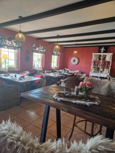 a dining room with tables and chairs and red walls at Hildebrandts Landhotel in Klettbach