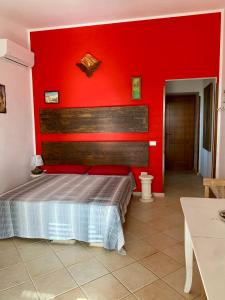 a bedroom with a red wall and a bed at n CELI in Uggiano la Chiesa