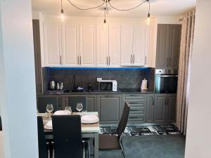 a kitchen with white cabinets and a table and chairs at DolceVita apartment in Como