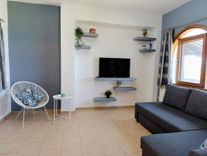 a living room with a couch and a tv at XD Al Mare in Ierissos