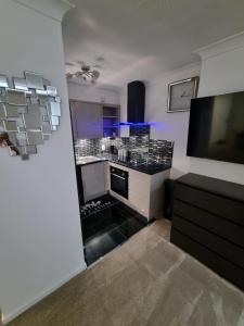 a kitchen with a black and white counter top at Stylish London Apartment & Free Parking in London