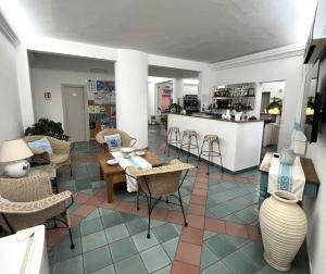 サンタ・テレーザ・ガッルーラにあるHotel Da Ceccoの椅子とテーブル、キッチンが備わる客室です。