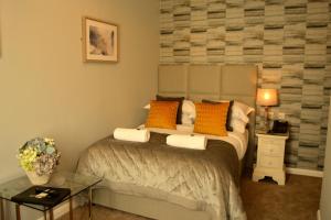 a bedroom with a bed with orange pillows on it at Le Bouchon Brasserie & Hotel in Maldon