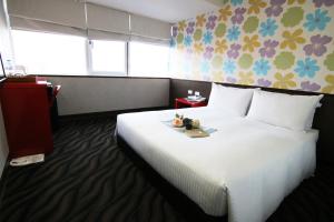 a hotel room with a large white bed with a tray on it at LIHO Hotel Tainan in Tainan