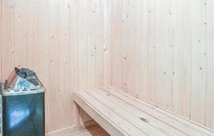 a wooden wall with a bench and a trash can at 3 Bedroom Nice Home In Hemmet in Hemmet