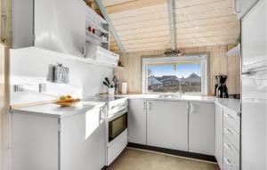 a kitchen with white cabinets and a window at Holiday Home Skovløkken Hejls Vi in Hejls