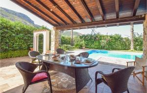 a patio with a table and chairs and a pool at Villa Tourig Beach in Mandra Capreria