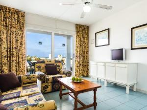 Una sala de estar con un sofá y un televisor. en BelleVue Aquarius, en Puerto del Carmen