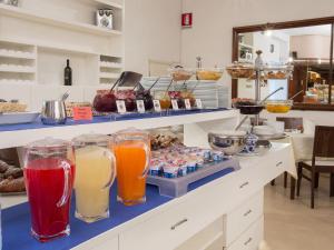 a kitchen with many different types of drinks on a counter at Hotel Minerva in Siena +254 photos
