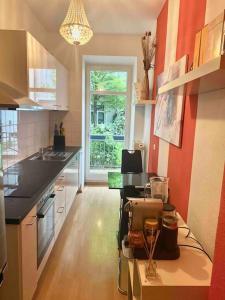 Una cocina con paredes rojas y encimera. en HQ Apartments Munich, en Múnich