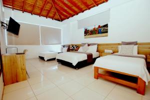 a bedroom with two beds and a tv in it at Hotel Blue Paradise inn in Turbo +20 photos