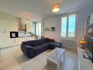 a living room with a blue couch and a kitchen at Appartamento Da Cesare a Porretta Terme Centro in Porretta Terme