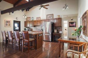a kitchen with a refrigerator and wooden cabinets at Hale Mauka in Captain Cook