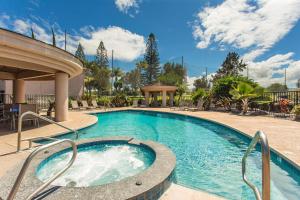 a swimming pool with a hot tub in a resort at Hale Okakopa in Waikoloa