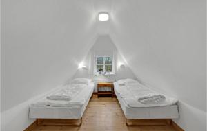 two beds in a room with a window at Two-Bedroom Holiday Home In Krusa in Kruså +12 photos