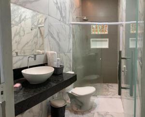 ein Badezimmer mit Toilette, Waschbecken und Dusche in der Unterkunft Amaro Residence in Santo Amaro + 16 Fotos